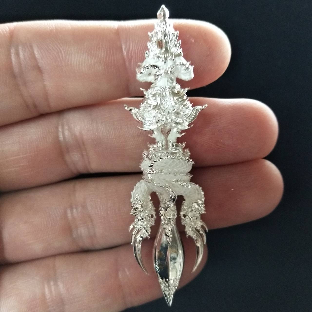 Silver Vajra Wessuwan amulet for wealth held in hand, showcasing intricate details and craftsmanship