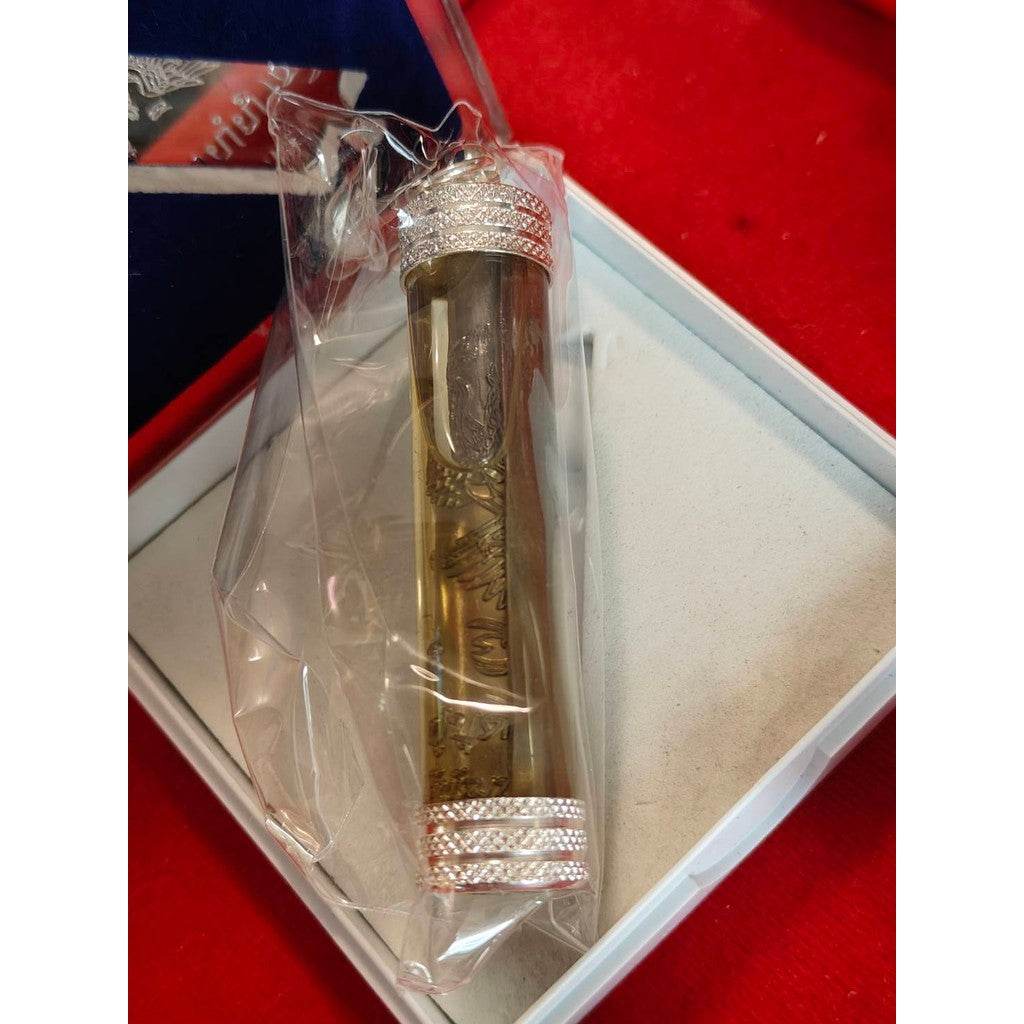 Takrut Phaya Nok Thued Thue amulet encased in a clear protective tube with silver caps inside a white box
