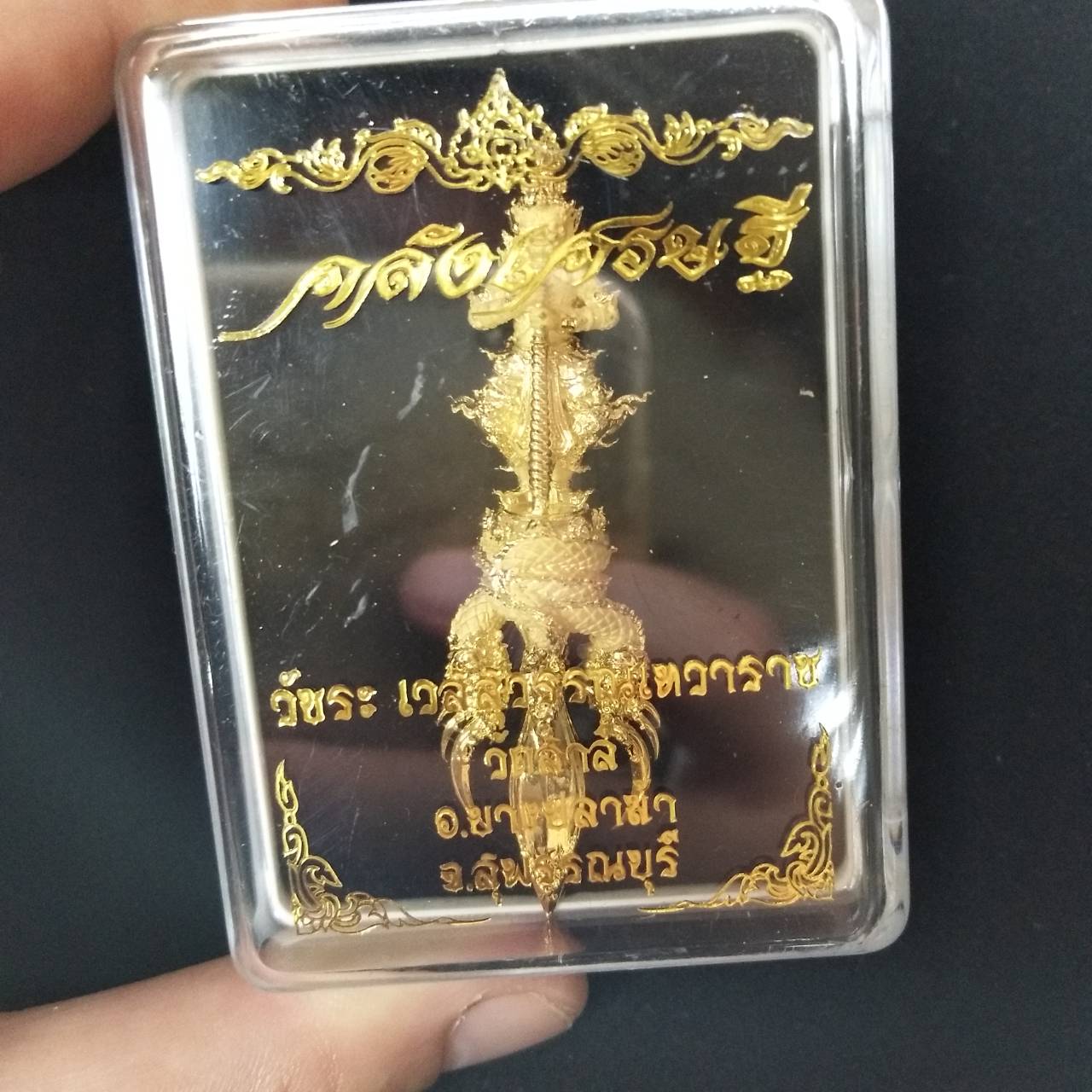 Vessuwan amulet for wealth encased in a protective plastic cover, showcasing intricate gold details