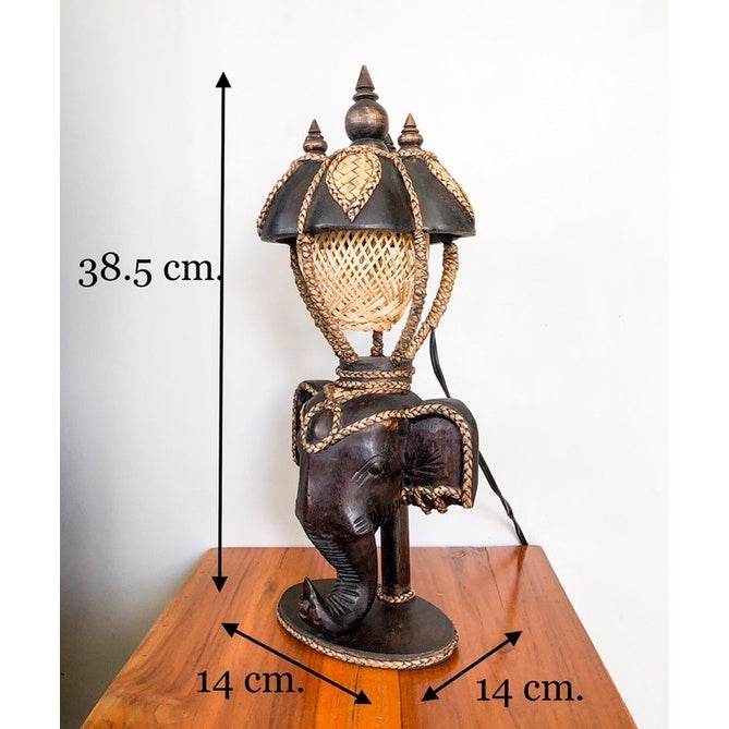 Vintage Thai home decor lamp featuring an elephant base with intricate woven lampshade on wooden table