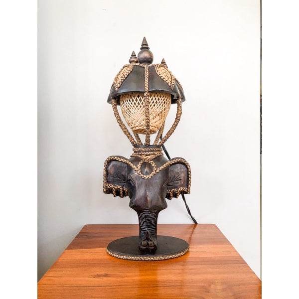 Vintage Thai home decor lamp with elephant design and woven rattan shade on wooden surface