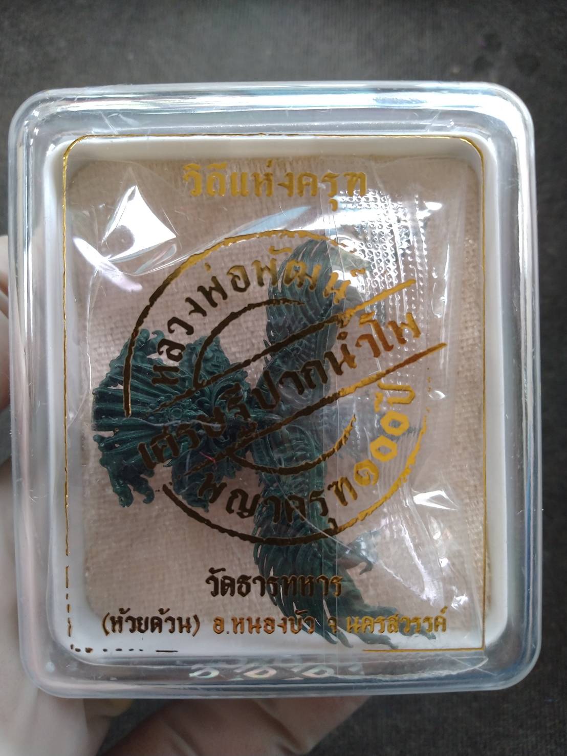 Phaya Krut amulet blessed by Luang Phor Phat in clear plastic box on stamped cloth