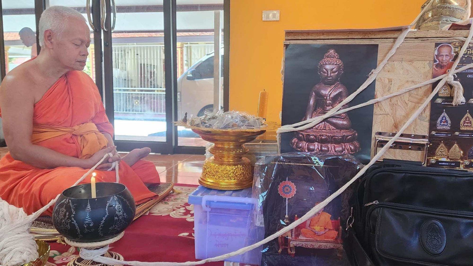 Mongkol Hemarat Kring spiritual charm placed near Buddha statue during Thai monk blessing ceremony by Thai Blessing Co
