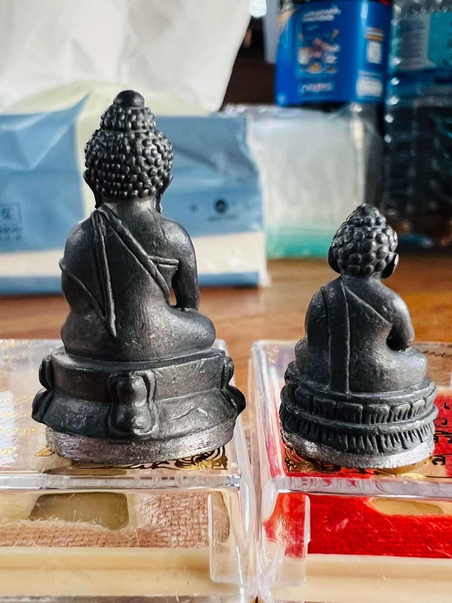 Mongkol Hemarat Kring spiritual charm metal Buddha amulet pair back view on plastic cases Thai Blessing Co