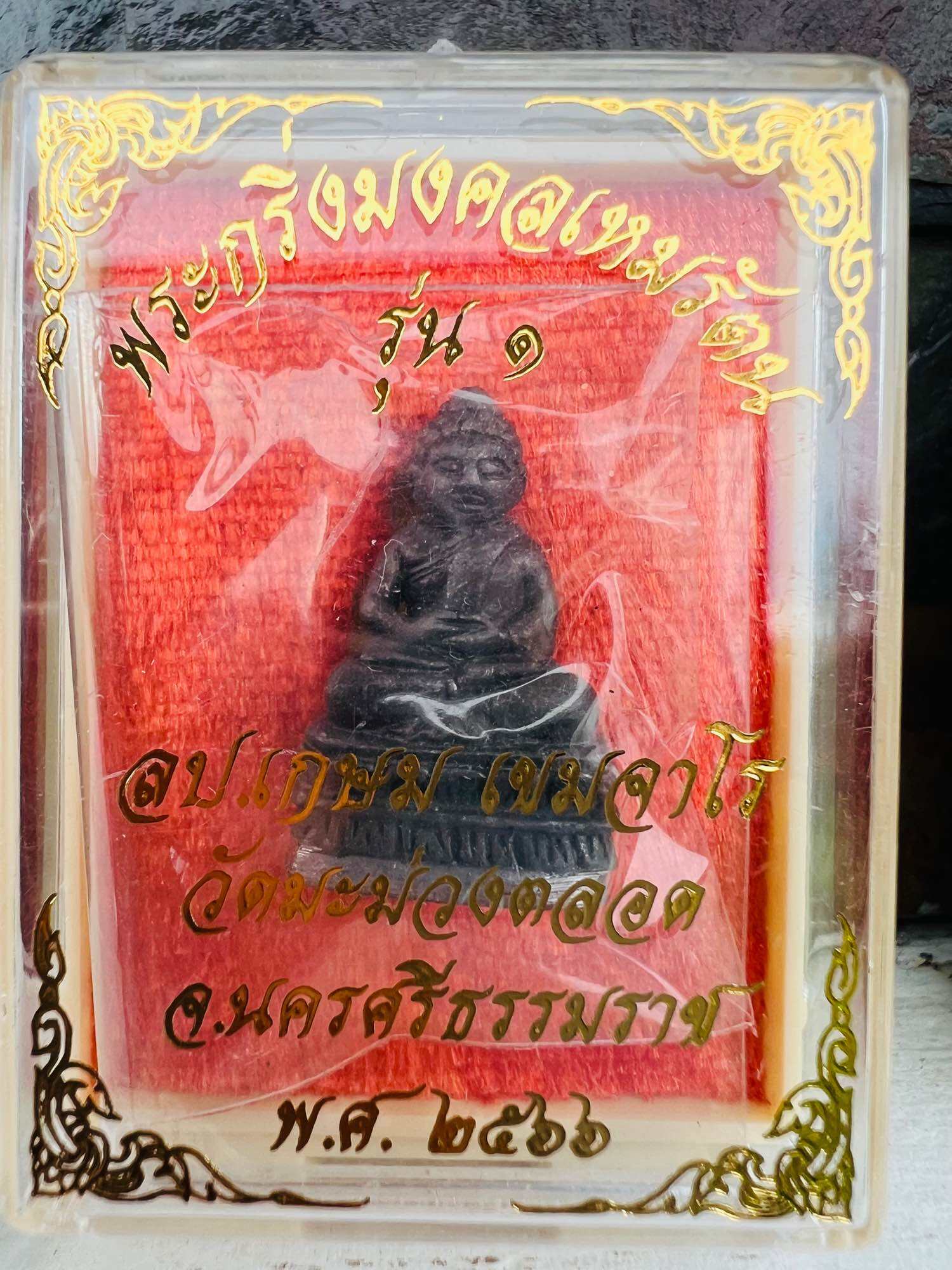Mongkol Hemarat Kring spiritual charm small black seated amulet in clear display case with red backing by Thai Blessing Co