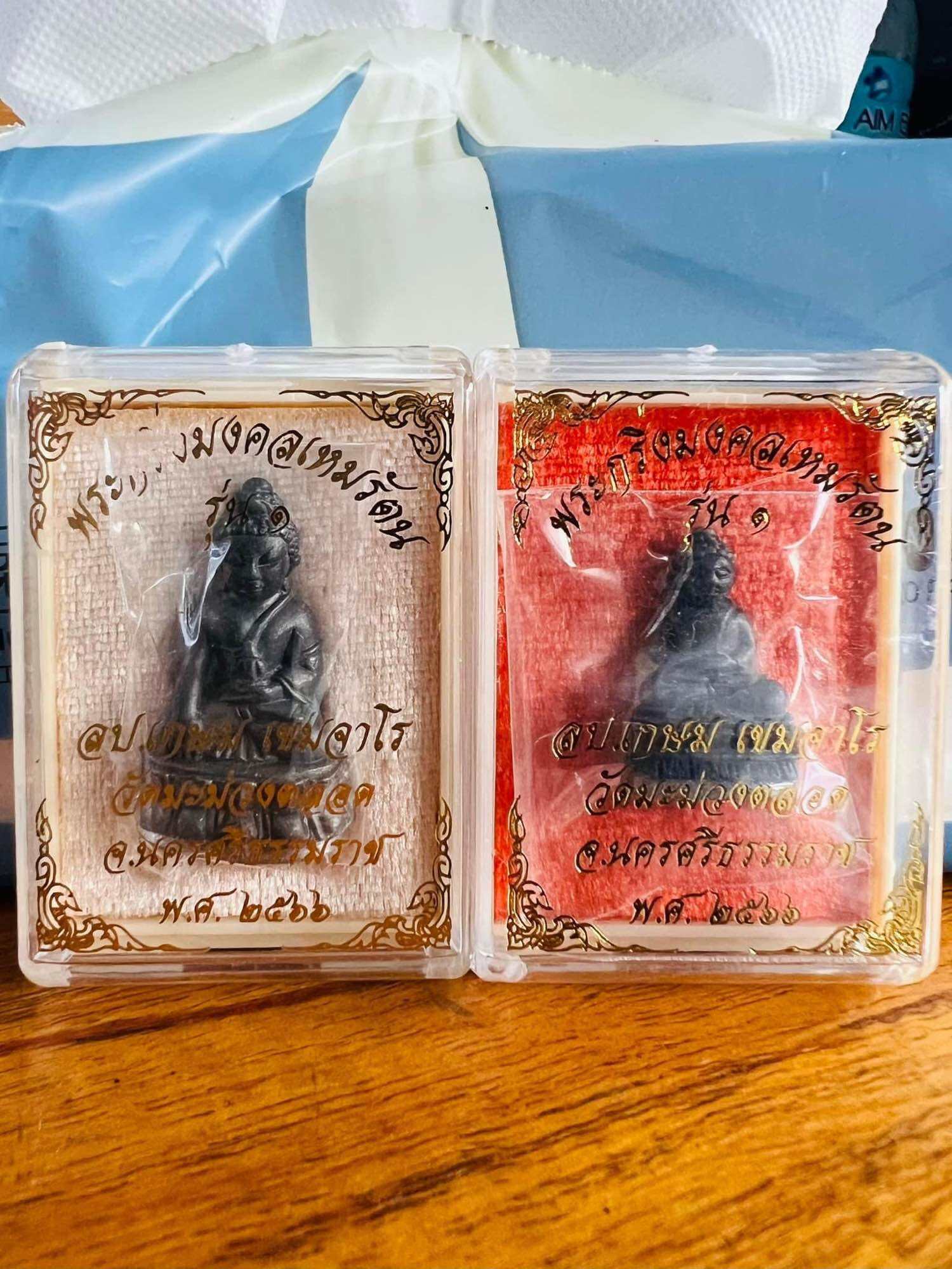 Mongkol Hemarat Kring spiritual charm black amulets in clear plastic cases with gold Thai script and red and beige backings