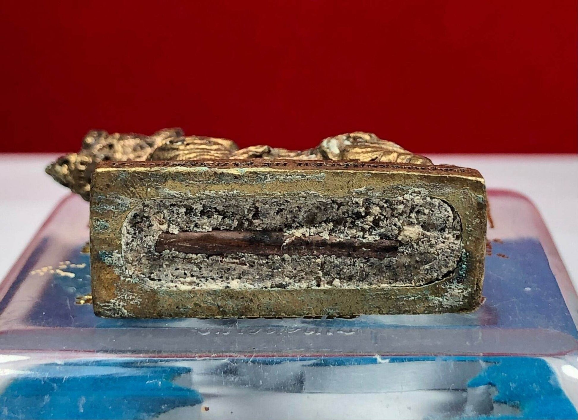 Close up of Singha Guardian Amulet base showing aged gold patina and exposed metal core inside cavity