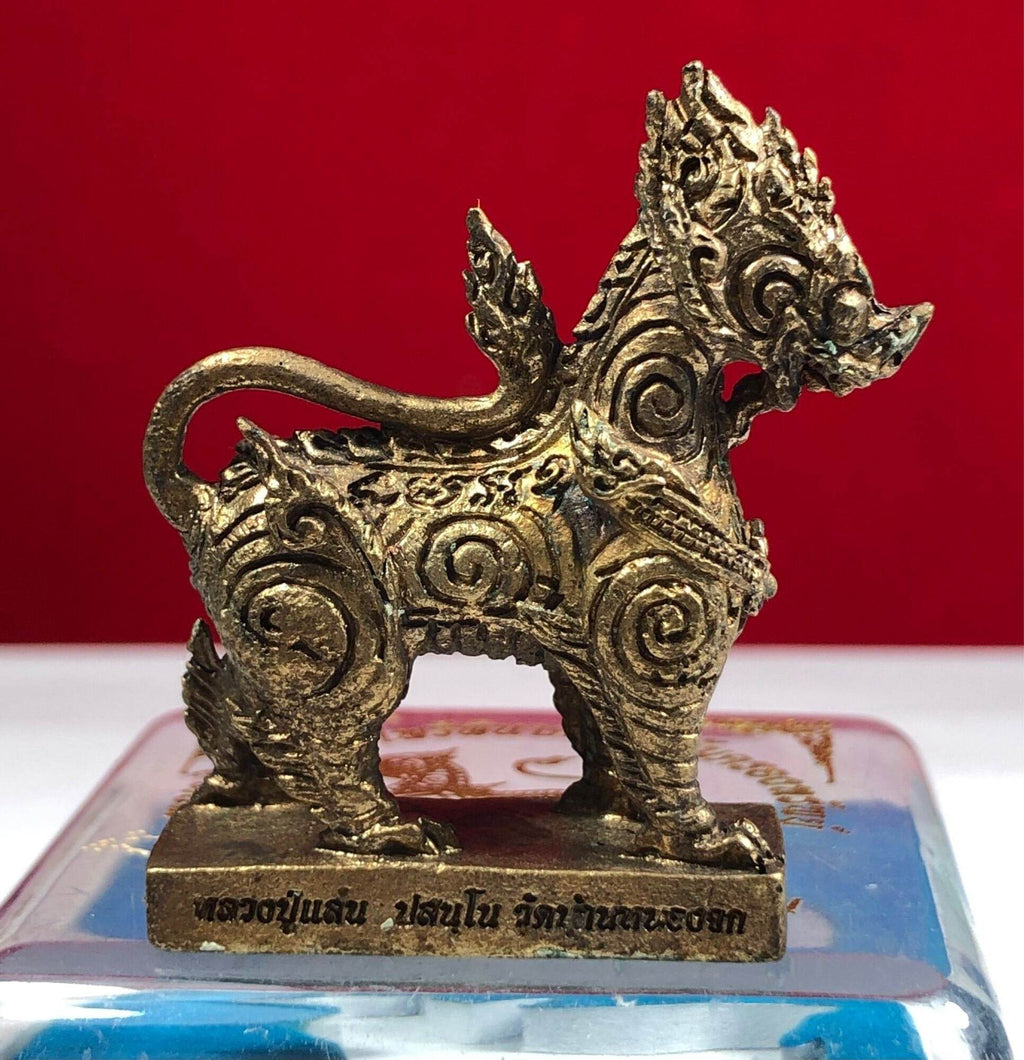 Gold ornate Singha Guardian Amulet figurine with intricate spiral carvings on rectangular base