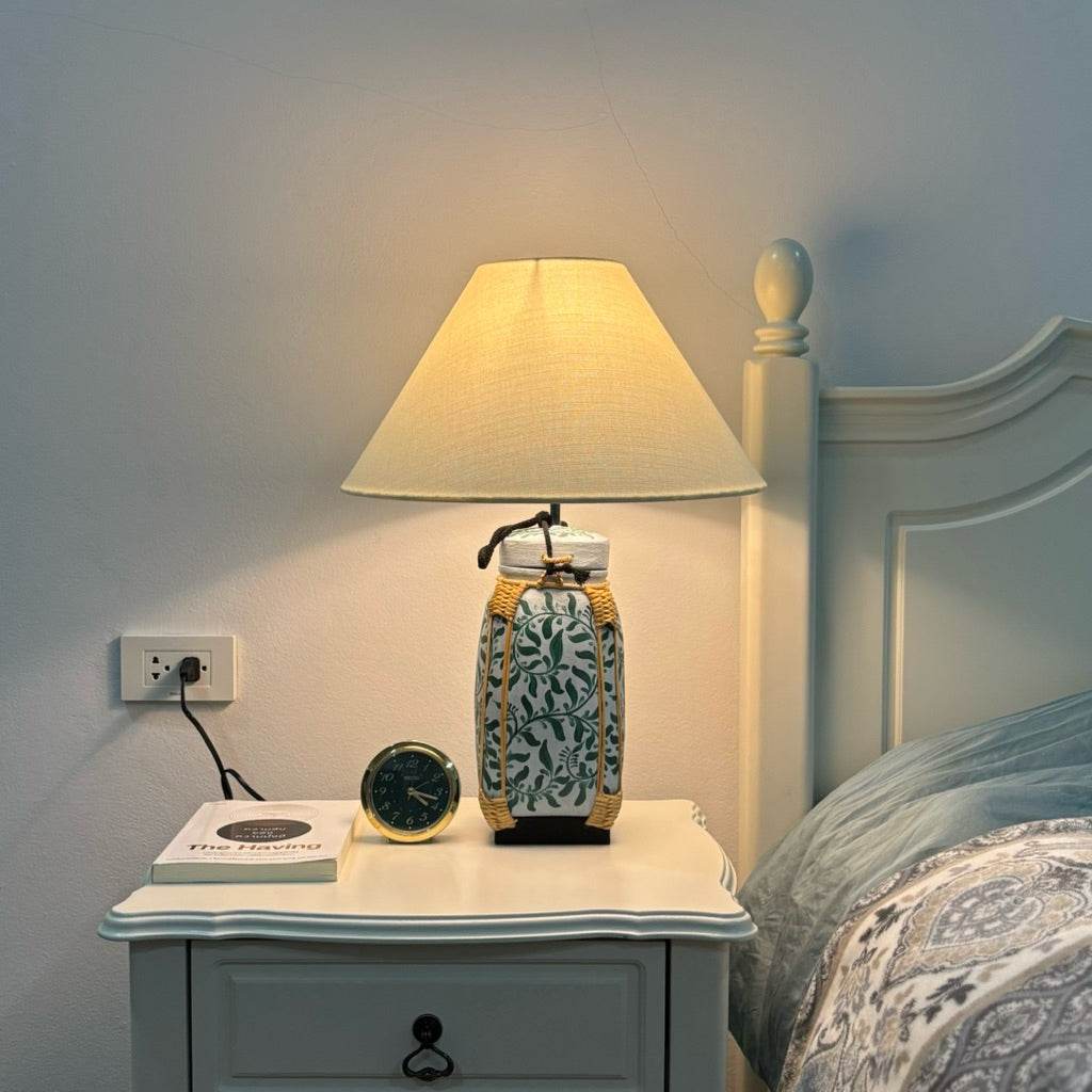 Woven bamboo rice basket lamp on bedside table with beige lampshade by One-Sake.com