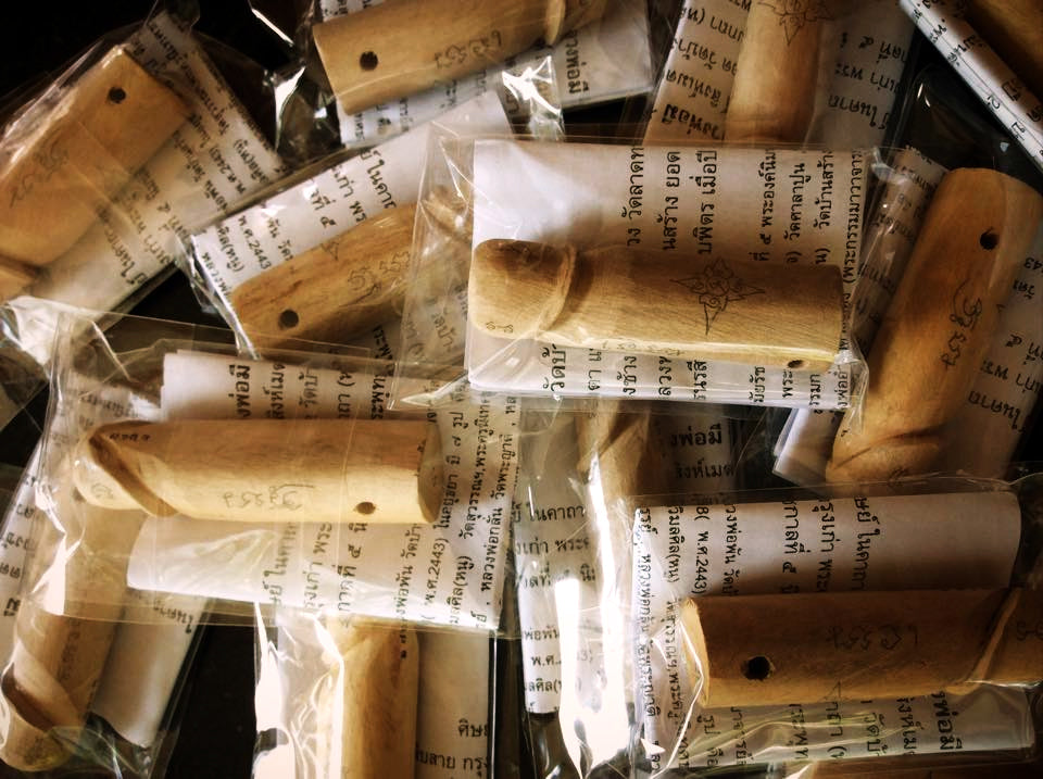 Collection of authentic palad khik amulets made from wood, individually packaged with Thai inscriptions