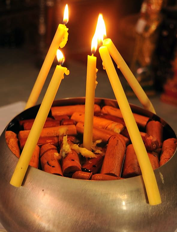 Traditional altar setup with candles and incense for blessing an authentic palad khik amulet